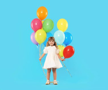 Açık mavi arka planda bir sürü renkli balonu olan şirin bir kız.