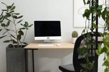 Biyofilik iç tasarım. Ofisinde bilgisayar ve ev bitkileri olan şık bir iş yeri
