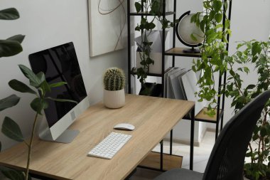 Biyofilik iç tasarım. Ofisinde bilgisayar ve ev bitkileri olan şık bir iş yeri