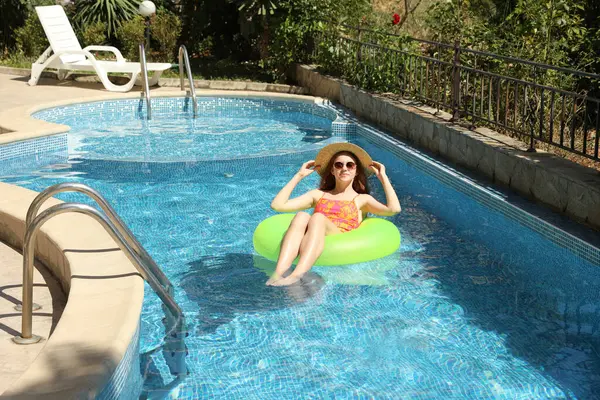 Yüzme havuzunda şişme yüzük takan güzel kız.