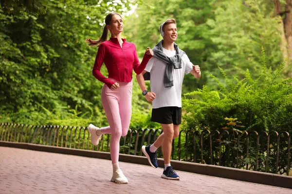 Parkta koşan mutlu çift, düşük açı. Sabah egzersizi