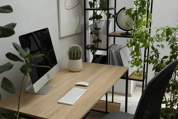 Biyofilik iç tasarım. Ofisinde bilgisayar ve ev bitkileri olan şık bir iş yeri