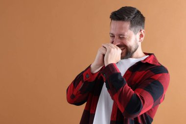 Koyu bej arka planda gülen yakışıklı adam, mesaj için boşluk.