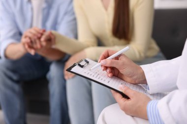 Tüp bebek (tüp bebek). Üreme kliniğinde doktorla randevusu olan çift, yakın plan.