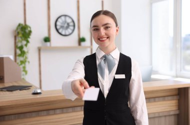 Gülümseyen resepsiyonistin portresi otel anahtar kartını içeride veriyor.