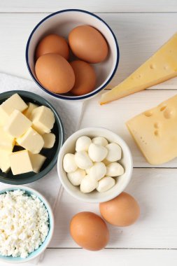 Farklı süt ürünleri ve yumurtalar beyaz ahşap masa üzerinde, düz yatıyordu