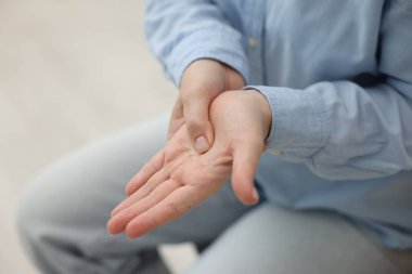 Evde el ağrısı çeken bir kadın, yakın plan.