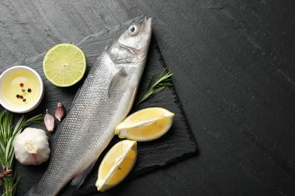 Siyah masadaki baharatlı taze çiğ deniz kabuğu balığı, üst görünüm ve metin için yer. Deniz ürünleri lezzetleri.