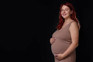 Siyah arka planda güzel hamile kadın, mesaj için boşluk