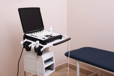Modern ultrason makinesi ve klinikte muayene yatağı
