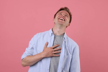 Pembe arka planda gülen yakışıklı bir adam. Pozitif duygu