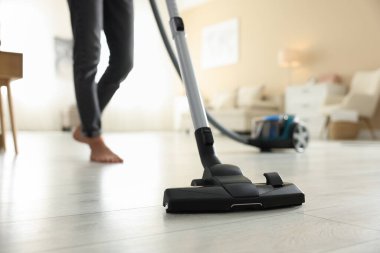 Yerleri elektrikli süpürgeyle temizleyen kadın, yakın çekim.