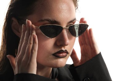 Siyah dudak kalemi olan, beyaz arka planda ıslak güneş gözlüğü takan güzel bir genç kadın.