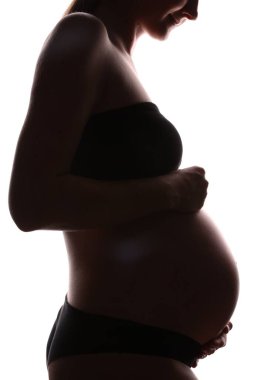 Beyaz arka planda hamile kadın silueti, yakın plan.