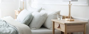 Yatağın yanında lambalar olan komodinlerin yanına.