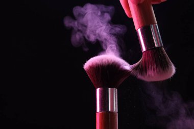 Siyah arka planda renk farlı makyaj fırçaları, yakın plan. Metin için boşluk