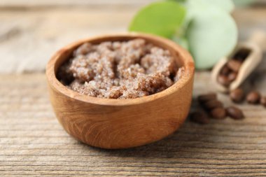 Doğal vücut fırçası ve kahve çekirdekleri ahşap masada, yakın plan.