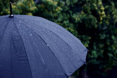 Dışarıda sağanak yağmur altında mavi şemsiye, yakın çekim. Metin için boşluk
