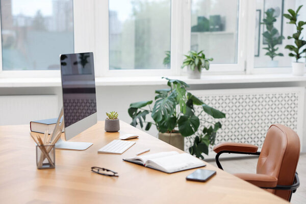 Stylish workplace with modern computer and stationery on wooden desk indoors