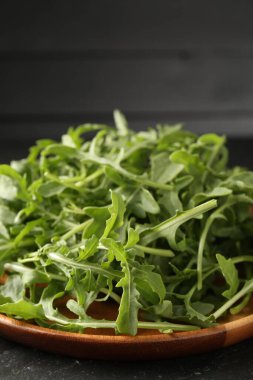 Taze yeşil roka yaprakları siyah masada, yakın plan.