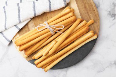Lezzetli Grissini çubukları ve peçete açık mermer masa, üst manzara