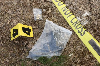 Adli tıp uzmanlığı. Delil, işaret ve polis bandı olan suç mahalli dışarıda, manzaranın üstünde.