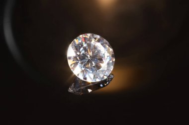 Karanlık ayna yüzeyinde parlak bir elmas, yakın plan.