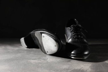 Gri zeminde dans etmek için siyah arka planda bir çift ayakkabı