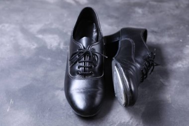 Gri yüzeyde step dansı için bir çift ayakkabı, yakın plan.