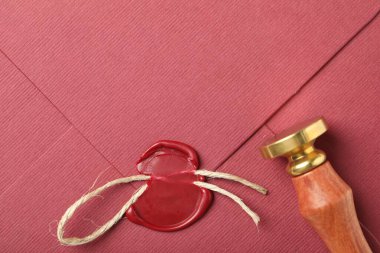 Üzerinde kırmızı balmumu mühür, ip ve pul olan güzel bir zarf.