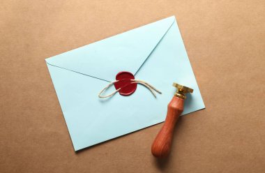 Güzel balmumu mühür, kırmızı mühürlü zarf ve bej arka planda sicim, üst manzara