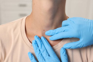 Hastanede genç bir kadının köstebeğini muayene eden doktor, yakın plan.