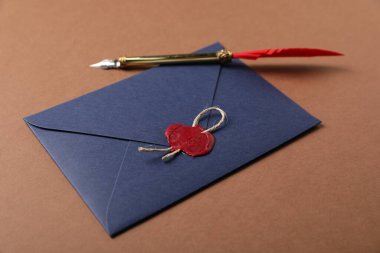 Kahverengi arka planda balmumu mühür, sicim ve dolmakalem ile zarf