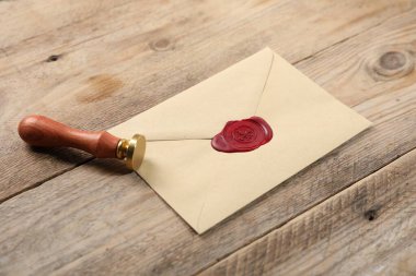 Balmumu mühürlü zarf ve ahşap masaya damgalı, yakın plan.