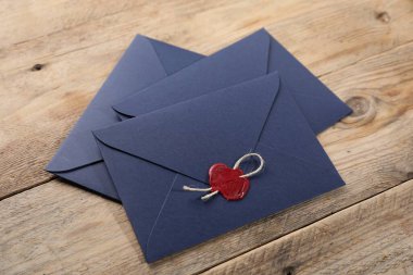 Tahta masanın üzerinde balmumu mühür ve sicimle zarflar.