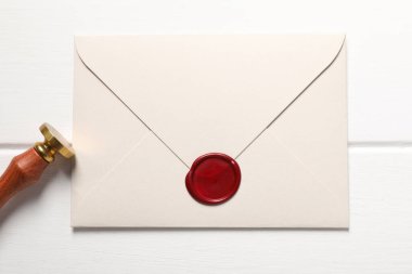 Balmumu mühürlü zarf ve beyaz ahşap masa, üst görünüm