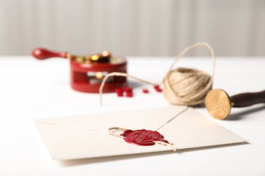 Balmumu mühür, ip ve damgalı zarf beyaz masa, yakın çekim