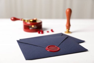 Balmumu mühür ve damgalı zarflar beyaz masada, yakın plan.