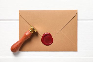 Balmumu mühürlü zarf ve beyaz ahşap masa, üst görünüm