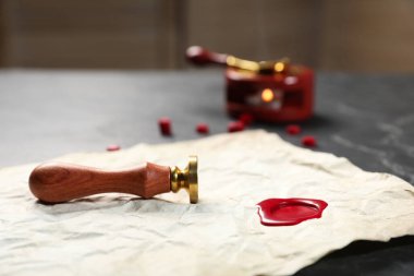 Balmumu mühürlü buruşuk kağıt ve siyah masa, yakın plan.