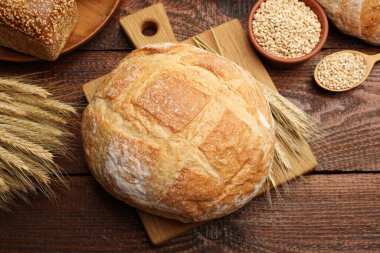 Taze ekmek somunları, tahıl ve buğday çivileri ahşap masa, düz yatıyordu.