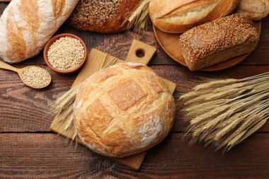 Taze ekmek somunları, tahıl ve buğday çivileri ahşap masa, düz yatıyordu.