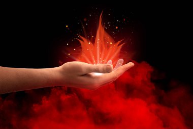 Kırmızı sihirli ışık, insanın elinden çıkan alevler gibi siyah arka planda dumanlanıyor. Aura, ruhani uygulama.