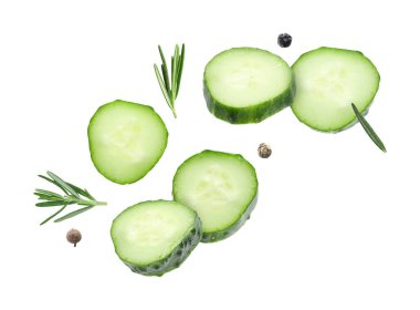 Beyaz arka planda salatalık dilimleri ve biberiye uçuşuyor