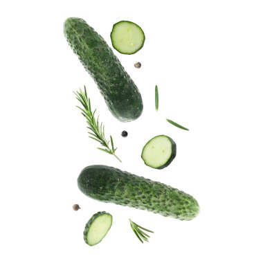 Beyaz arka plana düşen taze salatalıklar ve biberiye.