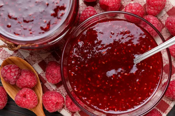 Bardakta ahududu reçeli ve masada böğürtlen.