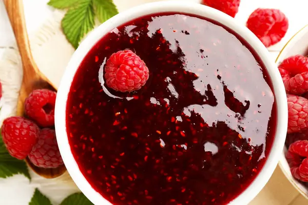 Tatlı ahududu reçeli kasede ve böğürtlenler masada, düz yatıyordu