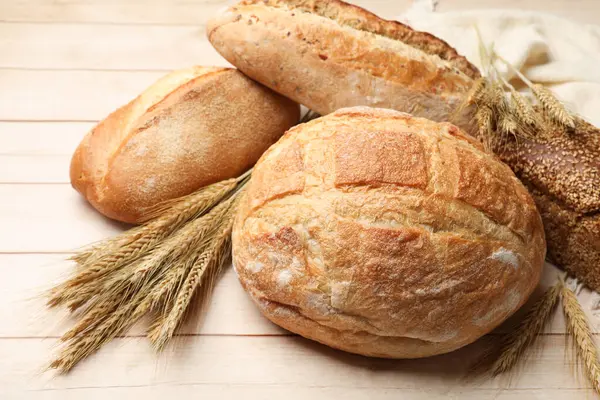 Tahta masada farklı ekmek ve buğday çivileri, yakın plan.