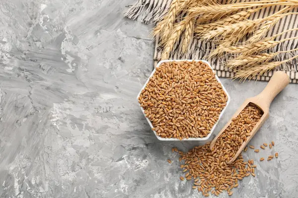 Kasede buğday taneleri, gri masada kepçeler ve çiviler düz yerde. Metin için boşluk