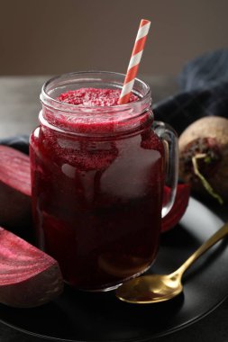Süper yemek. Mason kavanozunda smoothie tazeleniyor ve gri masada pancar kökleri kahverengi arka planda, yakın plan